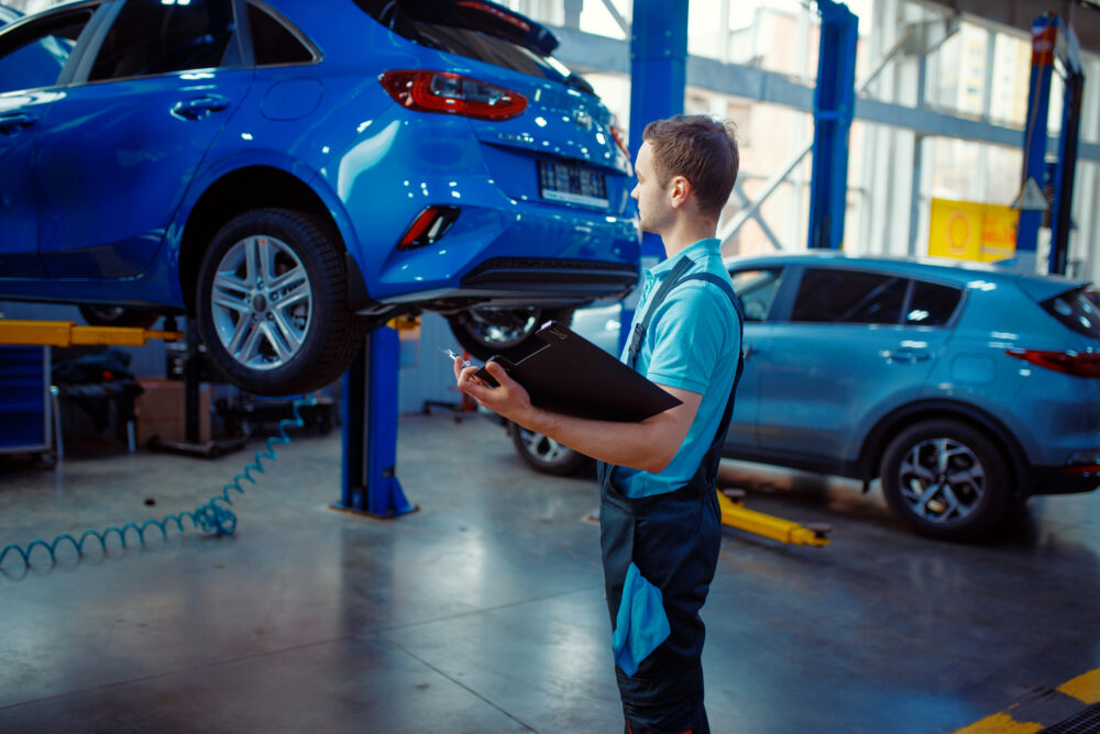Mechaniker mit einer Checkliste in einer Autowerkstatt